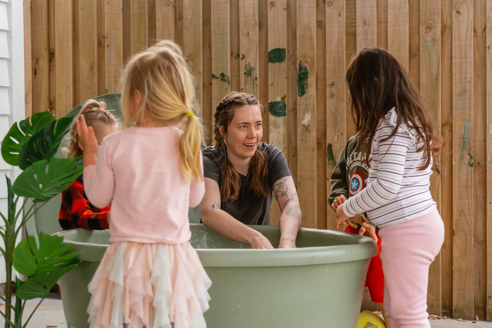 Children gathered around the PlayTray outdoors