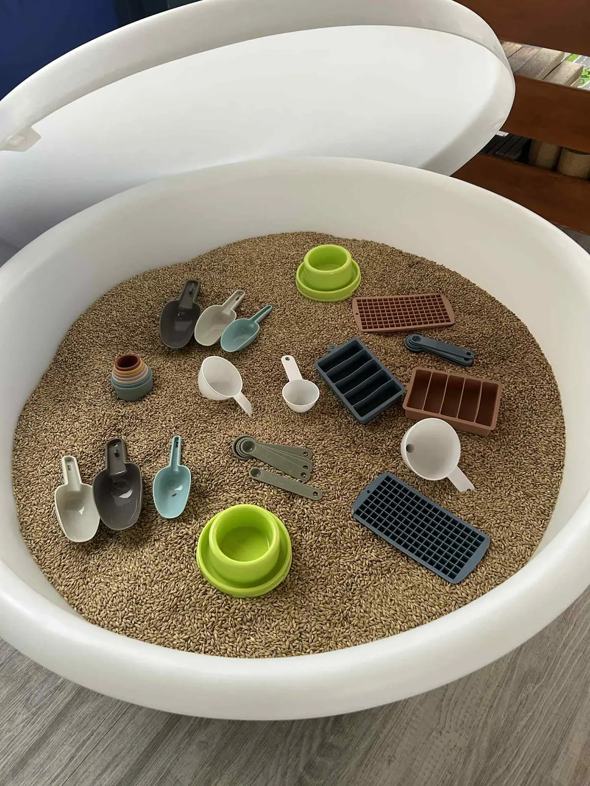 Overhead view of sand with measuring scoops and moulds in the PlayTray